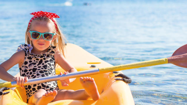 Little cute girl kayaking in the clear blue sea