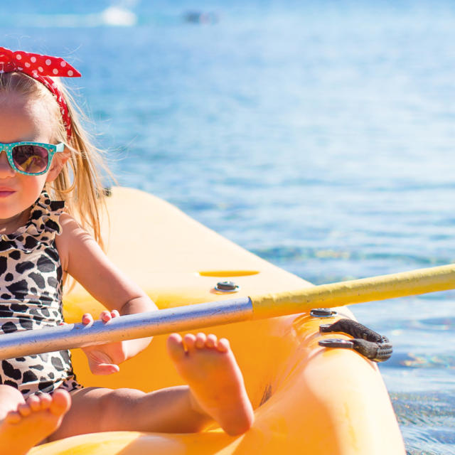 Little cute girl kayaking in the clear blue sea